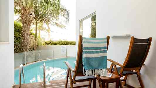 Två solstolar vid en liten pool. (AI-genererad text)