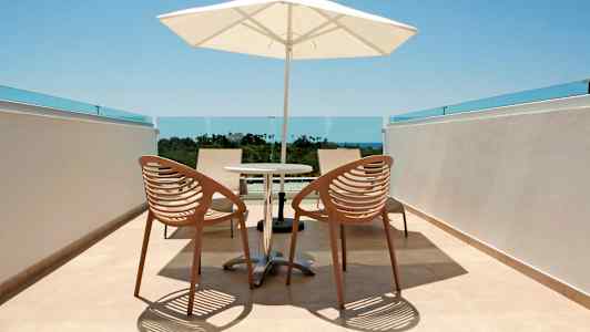 Bild på en terrass med två stolar, ett bord och en solskärm. (AI-genererad text)