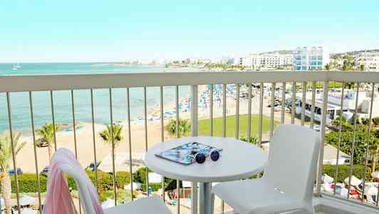 Utsikt från en balkong mot en strand och havet. (AI-genererad text)