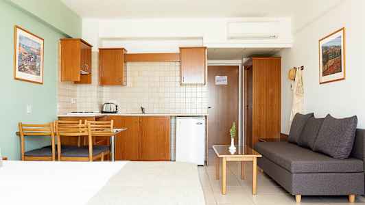 En hotellstudio med kök, matbord och sittgrupp. (AI-genererad text)