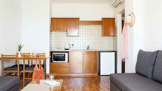 Ett litet kök med trämöbler och vita väggar. (AI-genererad text)