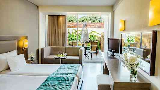 Ett hotellrum med en säng, sittgrupp och utgång till en terrass. (AI-genererad text)