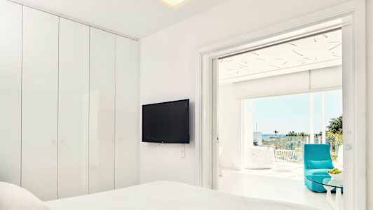 Modernt hotellrum med platt-TV och anslutande balkong med utsikt. (AI-genererad text)