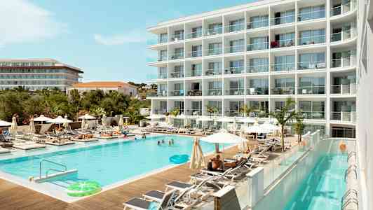 Ett hotell med en swimmingpool omgiven av solstolar och parasoller. (AI-genererad text)