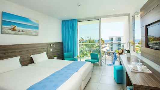 Modernt hotellrum med dubbelsängar, havsutsikt och en blå inredning. (AI-genererad text)