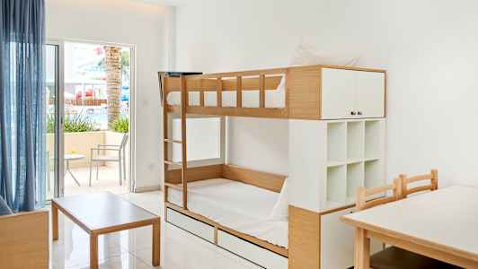 Bild av ett rum med våningssäng, ett bord och stolar, och en uteplats med sittmöbler. (AI-genererad text)