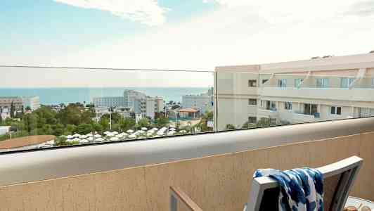 Utsikt från balkong över hotellområde och hav. (AI-genererad text)