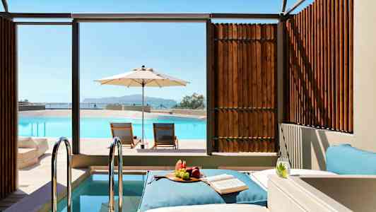 Solstolar vid en pool med parasoll och snacks på en dagbädd. (AI-genererad text)