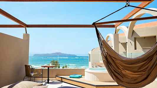 Takterrass med utsikt över havet, inkluderar hängmatta, bord och jacuzzi. (AI-genererad text)