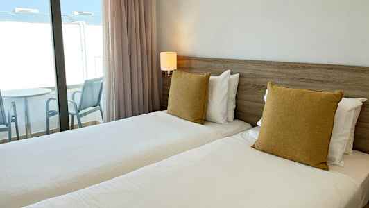 Bild på ett hotellrum med två enkelsängar och balkong. (AI-genererad text)