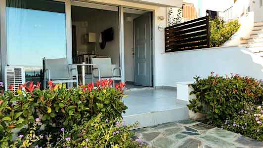 Uteplats med två stolar och bord framför en dörr och glasparti. (AI-genererad text)