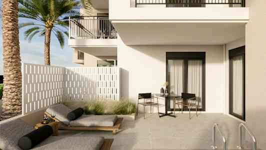 En ljus uteplats med solsängar, ett bord och stolar intill ett hus samt en pool. (AI-genererad text)