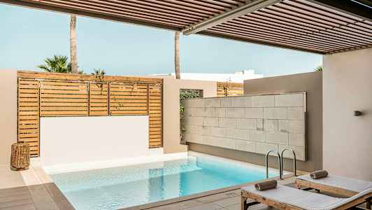 Privat poolområde med solstolar och trästaket. (AI-genererad text)