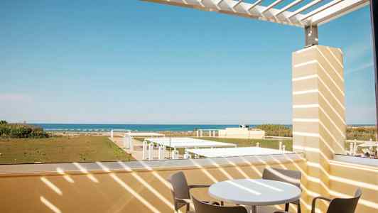 Utsikt från en terrass med utemöbler mot havet. (AI-genererad text)