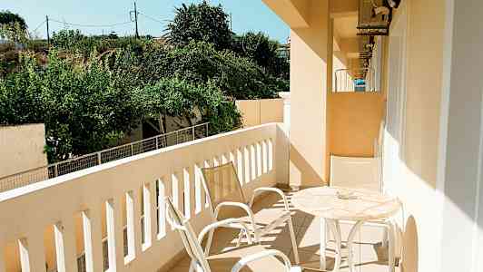 En balkong med trädgårdsutsikt, möblerad med bord och stolar. (AI-genererad text)