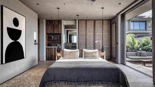 Moderna sovrum med stor säng och öppen glasfasad som vetter mot uteplats. (AI-genererad text)