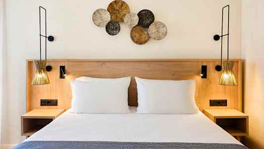 Säng med två kuddar och dekorationer på väggen. (AI-genererad text)