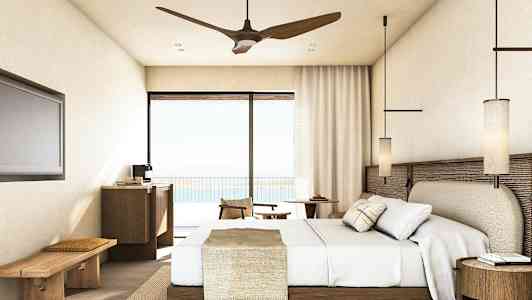 En hotellrum med en säng, möbler och balkongdörr med utsikt. (AI-genererad text)