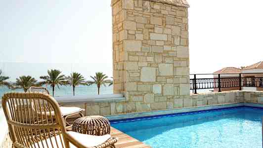 Terrass med pool, solstolar och utsikt över havet. (AI-genererad text)