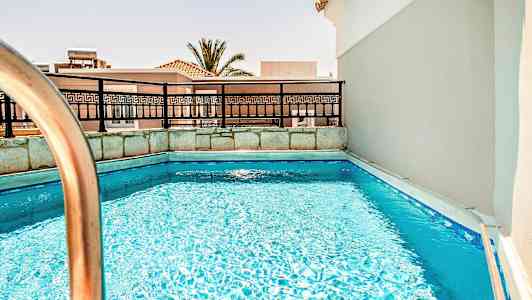 Bild av en liten pool med räcke och byggnader i bakgrunden. (AI-genererad text)