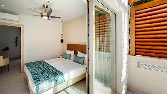 Ett ljust sovrum med en dubbelsäng och access till en terrass. (AI-genererad text)