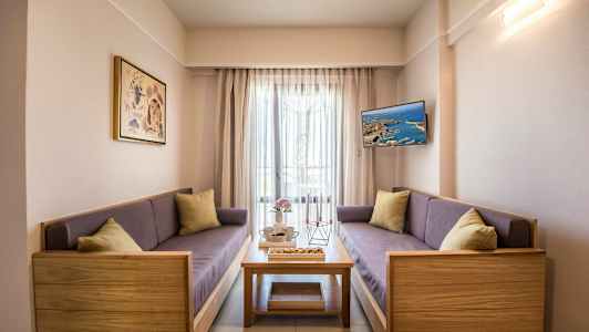 Ett vardagsrum med två soffor, ett soffbord och en väggmonterad TV. (AI-genererad text)