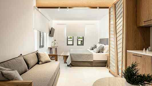 Modernt inredd hotellsvit med sittmöbler, säng och köksavdelning. (AI-genererad text)