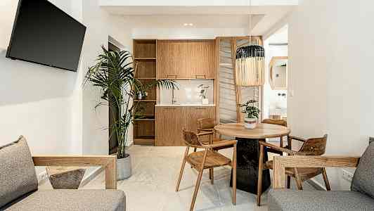 Modernt vardagsrum med möbler i trä, en rund matbord och en växt. (AI-genererad text)