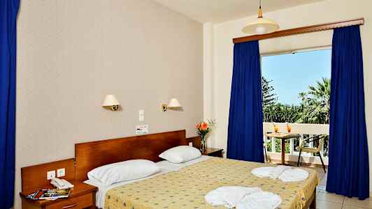 Interiör av ett sovrum med en dubbelsäng, nattygsbord och utsikt mot en balkong. (AI-genererad text)