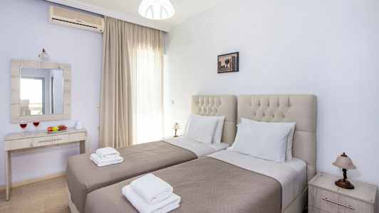 Två enkelsängar i ett sovrum med en spegelbyrå och nattduksbord. (AI-genererad text)