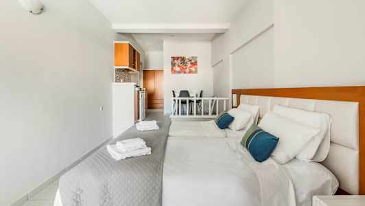 Ett hotellrum med två sängar och ett kök i bakgrunden. (AI-genererad text)