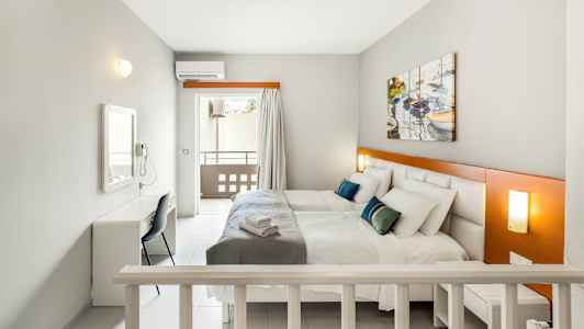 Rum med två sängar, ett skrivbord och en balkong. (AI-genererad text)