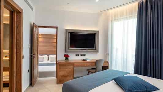 Ett hotellrum med modern inredning, en säng, ett skrivbord och en TV. (AI-genererad text)