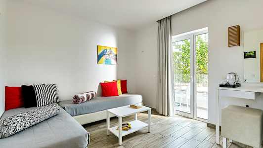 Ett rum med sittplats och bord, inrett med ljusa färger. (AI-genererad text)