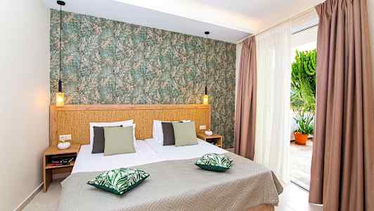 Sovrum med dubbelsäng, gröna kuddar och dekorerad vägg. (AI-genererad text)