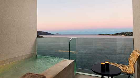 Utsikt över havet från en balkong med en privat pool, bord och stol. (AI-genererad text)