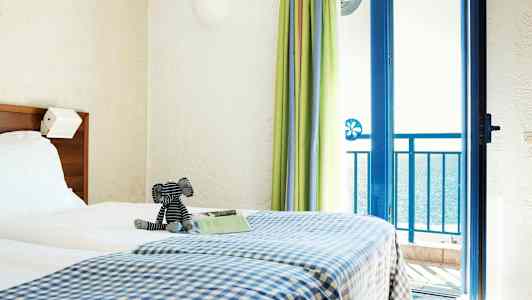 Rum med en  dubbelsäng och havsutsikt. (AI-genererad text)