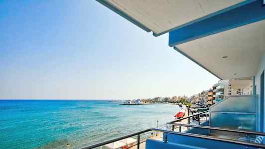 Utsikt från en balkong över havet och en strandpromenad. (AI-genererad text)