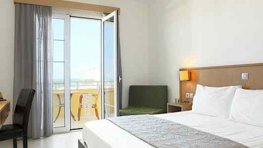 Ett hotellrum med en dubbelsäng och en balkong med utsikt. (AI-genererad text)