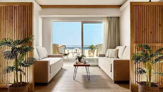 Modernt vardagsrum med två soffor och utsikt mot terrass och hav. (AI-genererad text)