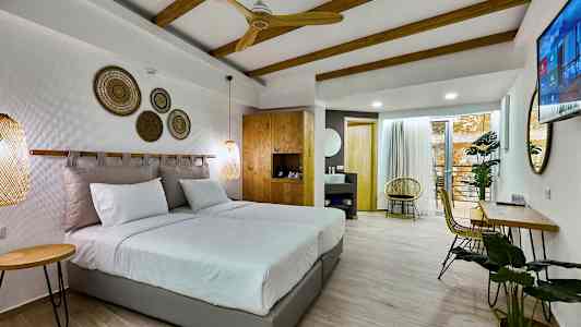 Modernt hotellrum med dubbelsäng, trädetaljer och sittmöblemang. (AI-genererad text)