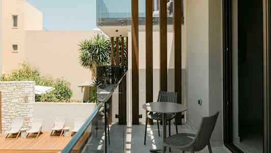 En balkong med möbler, i närheten av en pool och solstolar. (AI-genererad text)