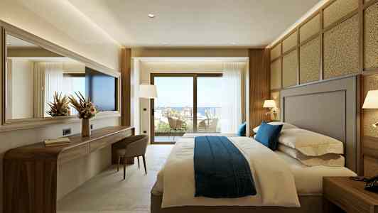 Ett hotellrum med en stor säng och fönster som öppnar upp mot en balkong med utsikt. (AI-genererad text)