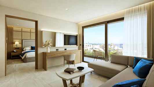 Ett modernt hotellrum med vardagsrumsdel, separat sovrum och utsikt mot havet genom stora fönster. (AI-genererad text)