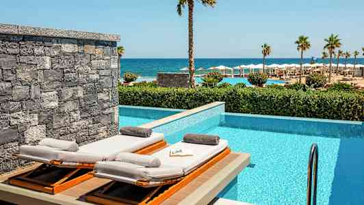 Solstolar vid en privat pool med havsutsikt. (AI-genererad text)