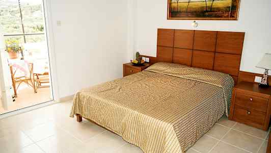 Sovrum med en dubbelsäng och utsikt mot en balkong. (AI-genererad text)