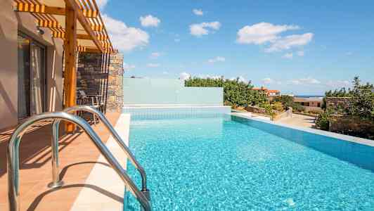 En infinitypool vid ett hus med solsken och utsikt över grönska och himmel. (AI-genererad text)