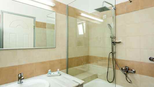 Ett badrum med dusch och tvättställ. (AI-genererad text)