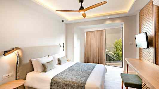 Ett modernt sovrum med en stor säng, ett skrivbord och en TV. (AI-genererad text)