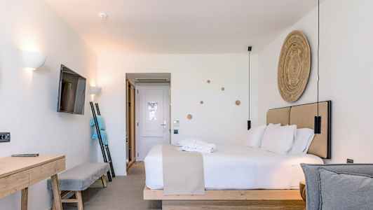 Modernt hotellrum med dubbelsäng, TV på väggen och skrivbord. (AI-genererad text)